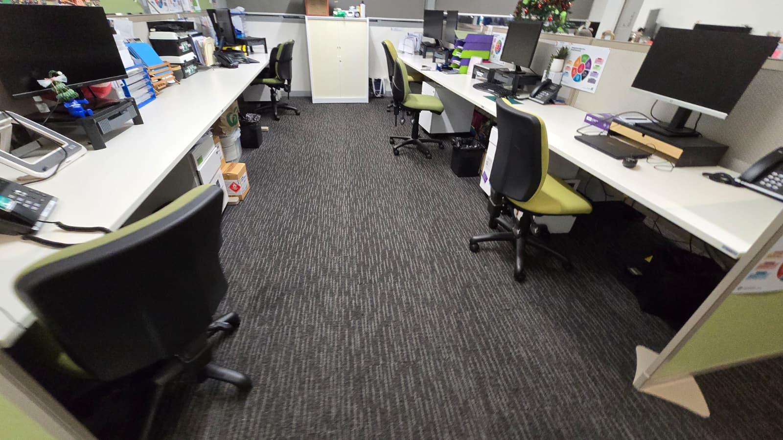Open plan office with freshly cleaned carpet between rows of desks