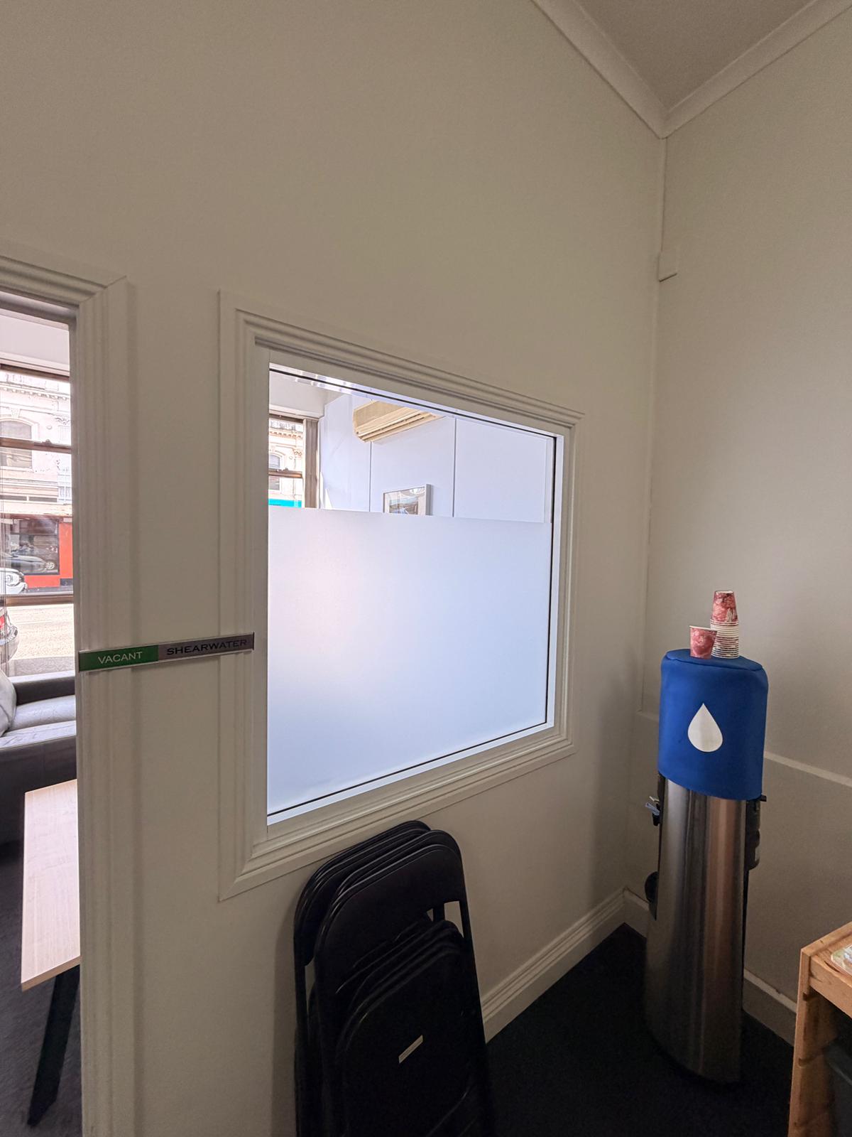 Bright clean room with a frosted glass window and water cooler